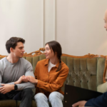 A man and woman sitting on a couch receiving divorce counseling.