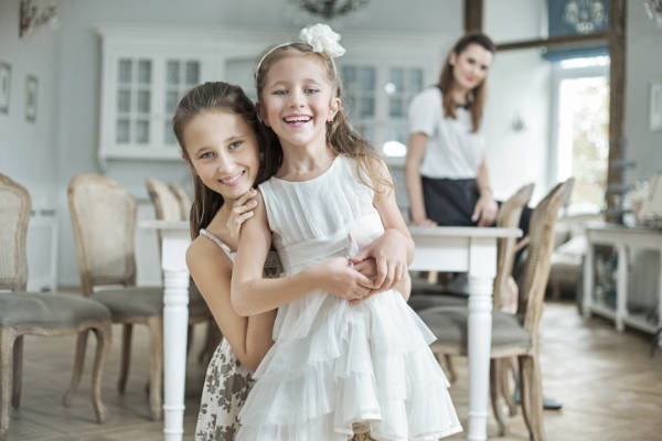 Two little girls are posing for a picture in a dining room during divorce counseling.