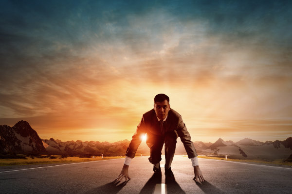 A businessman is standing on the road contemplating his mental health at sunset.