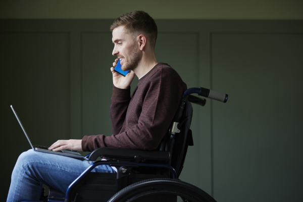 A man in a wheelchair using a phone to discuss mental health.