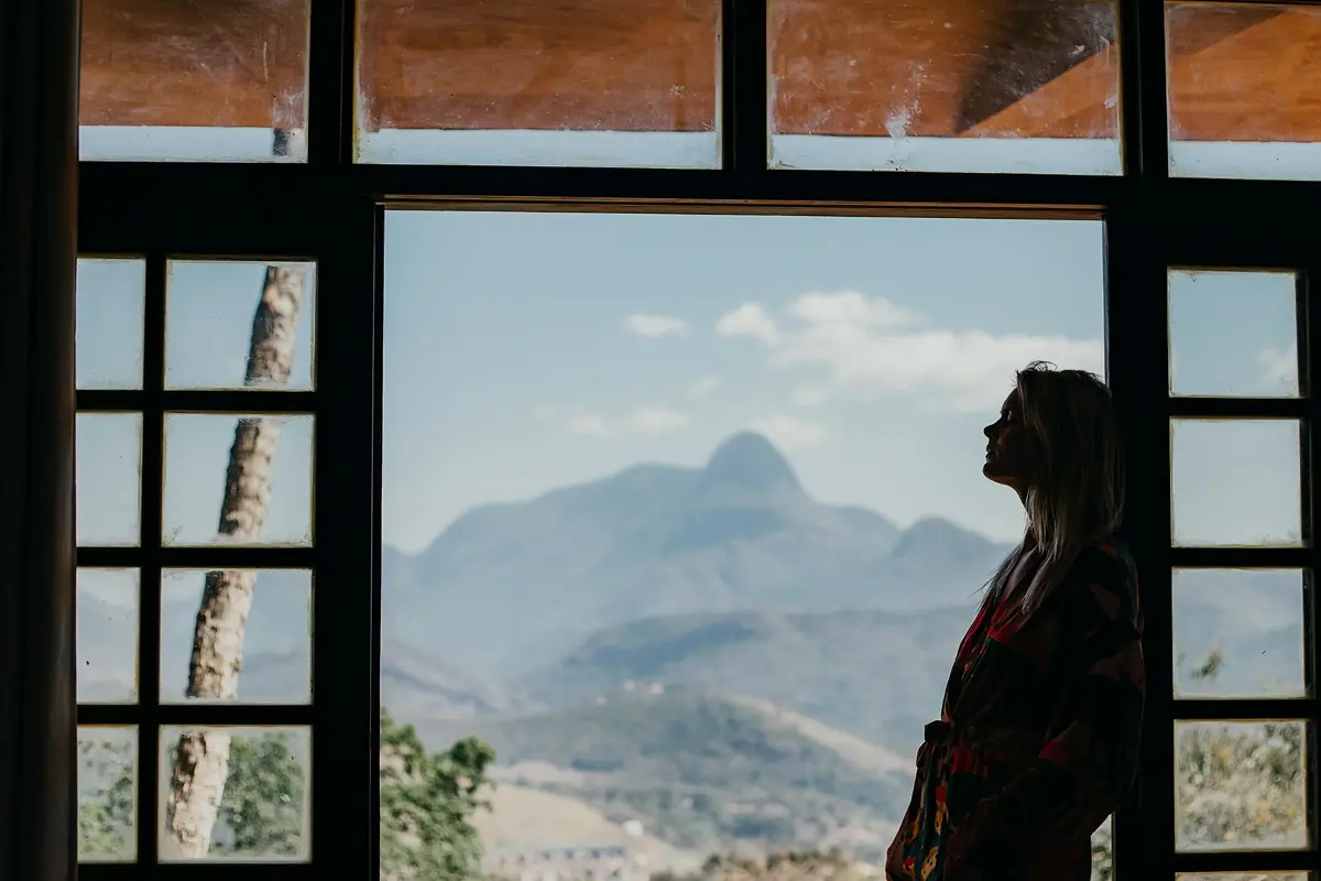 Woman standing in a doorway and looking toward distant mountains